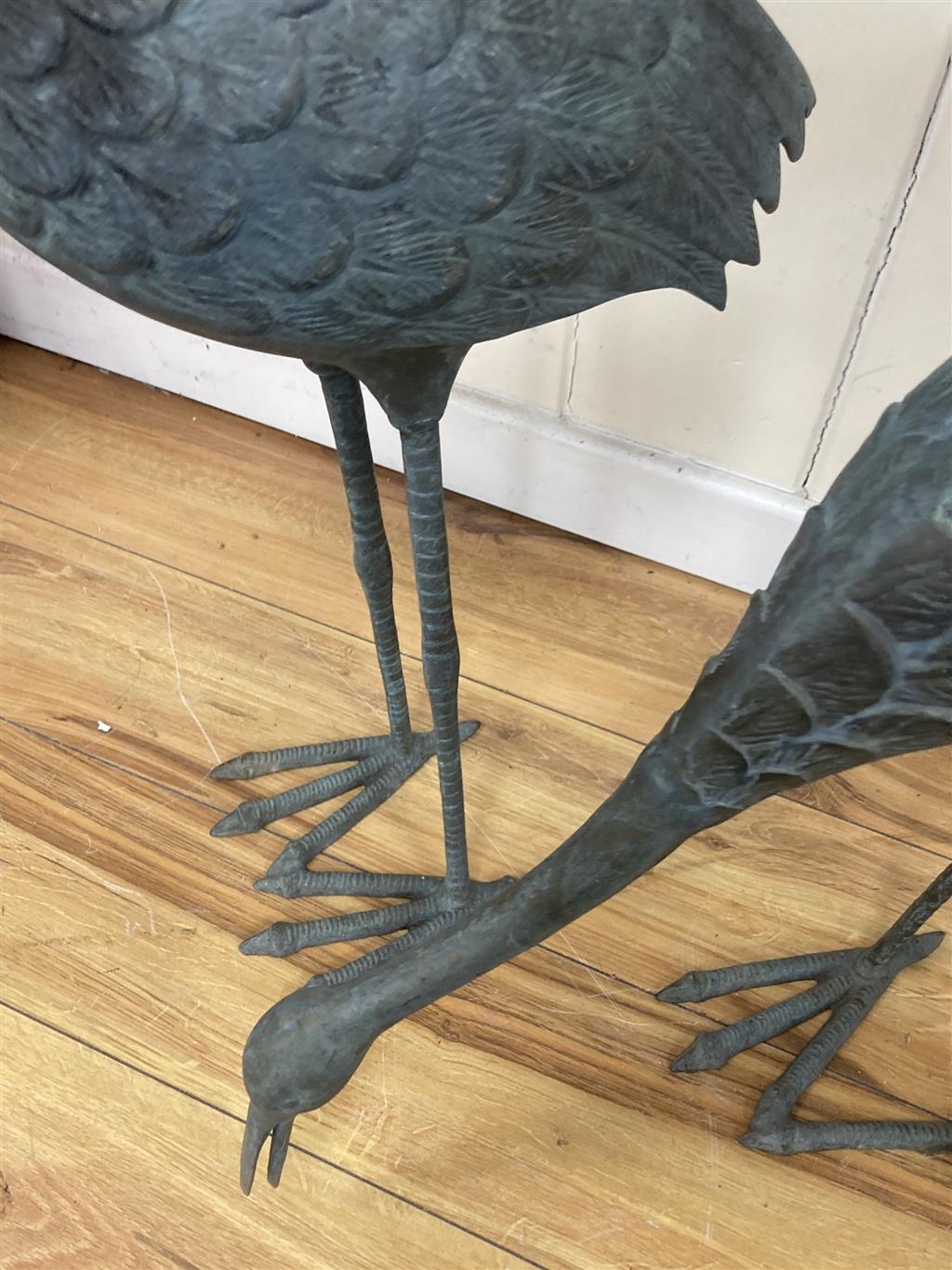A pair of patinated bronze cranes, larger 89cm high